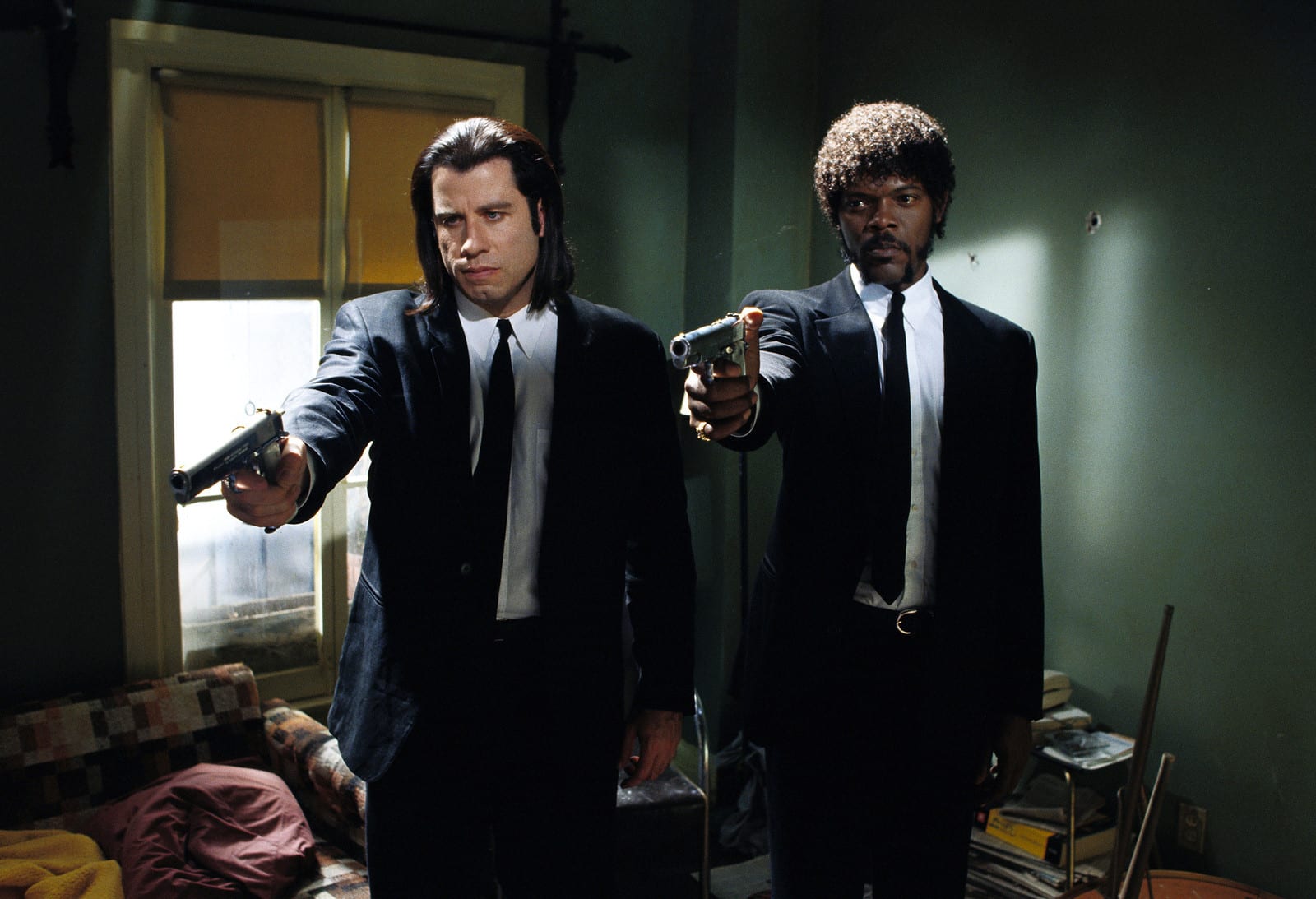 جان تراولتا و ساموئل ال جکسون با کت و شلوار مشکلی و اسلحه های نشانه رفته در Pulp Fiction
