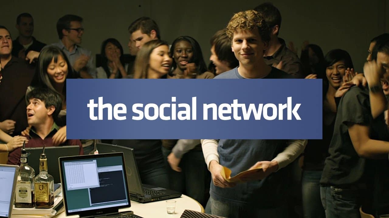 Jesse Eisenberg در میان همکاران و چند لپتاپ روی میز در فیلم The Social Network
